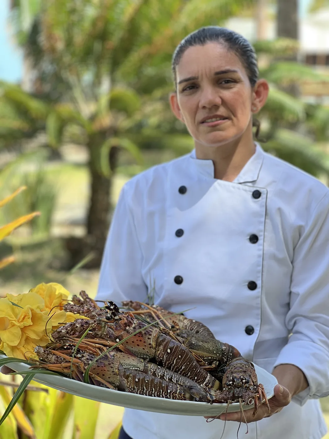 Cozinheira do Prado Areia Beach segurando uma travessa de lagostas frescas
